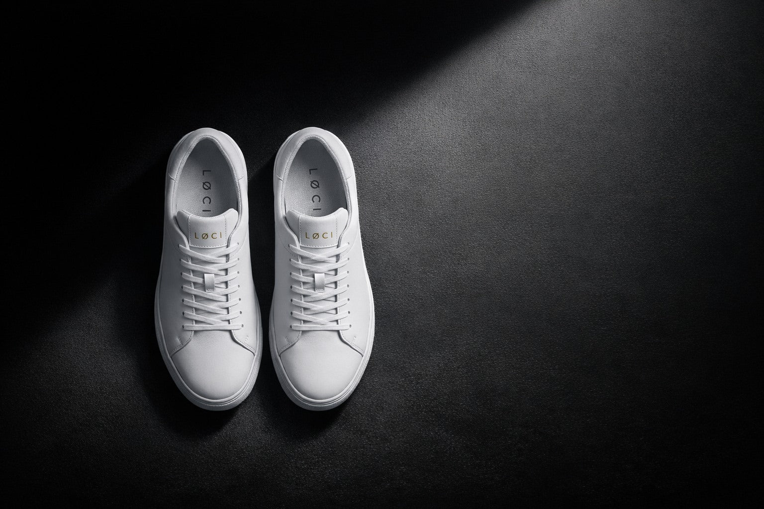 White LØCI sneaker in a pool of light